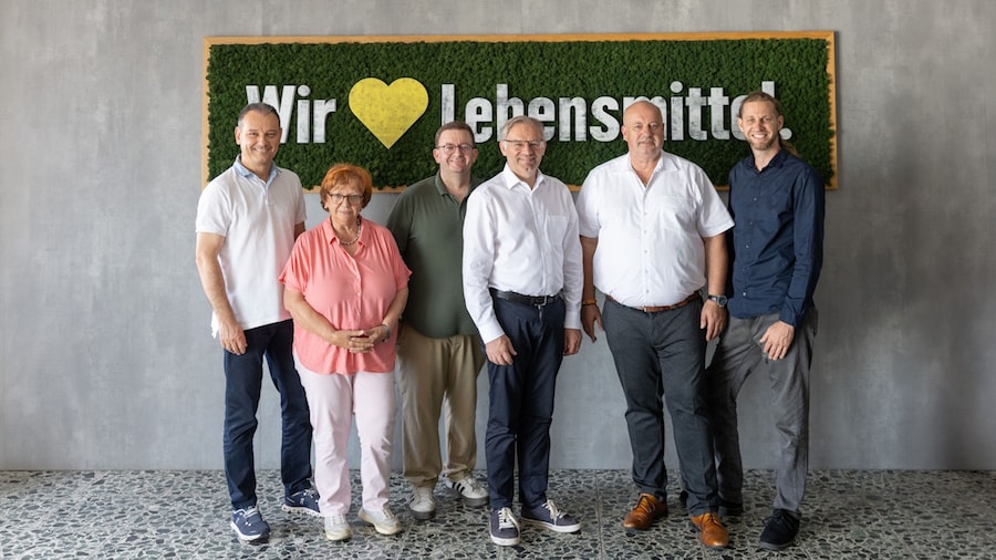 Sechs Personen vor EDEKA Wandbild