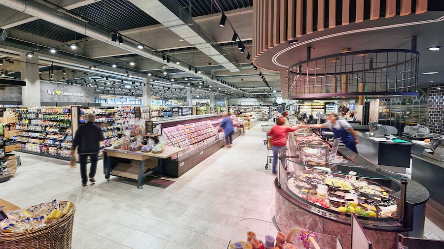 Moderne Bedientheke für regionale Fleisch- und Wurstprodukte mit Selbstbedienungs-Kühltheke davor.