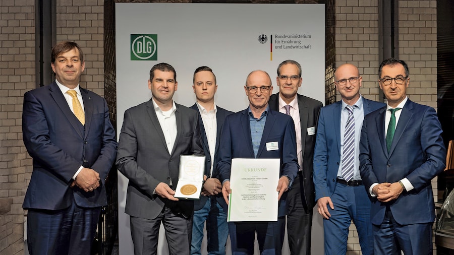 Cem Özdemir und Hubertus Paetow posieren mit Preisträgern, die ihre Urkunde und Medaille zeigen.