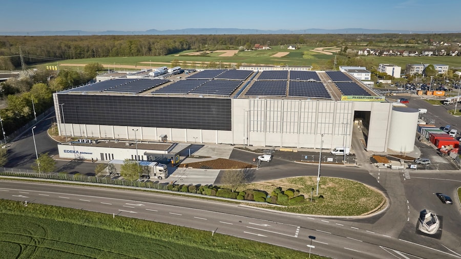 Luftaufnahme der Tiefkühllager-Baustelle mit Photovoltaik-Modulen und Zufahrtsstraße.
