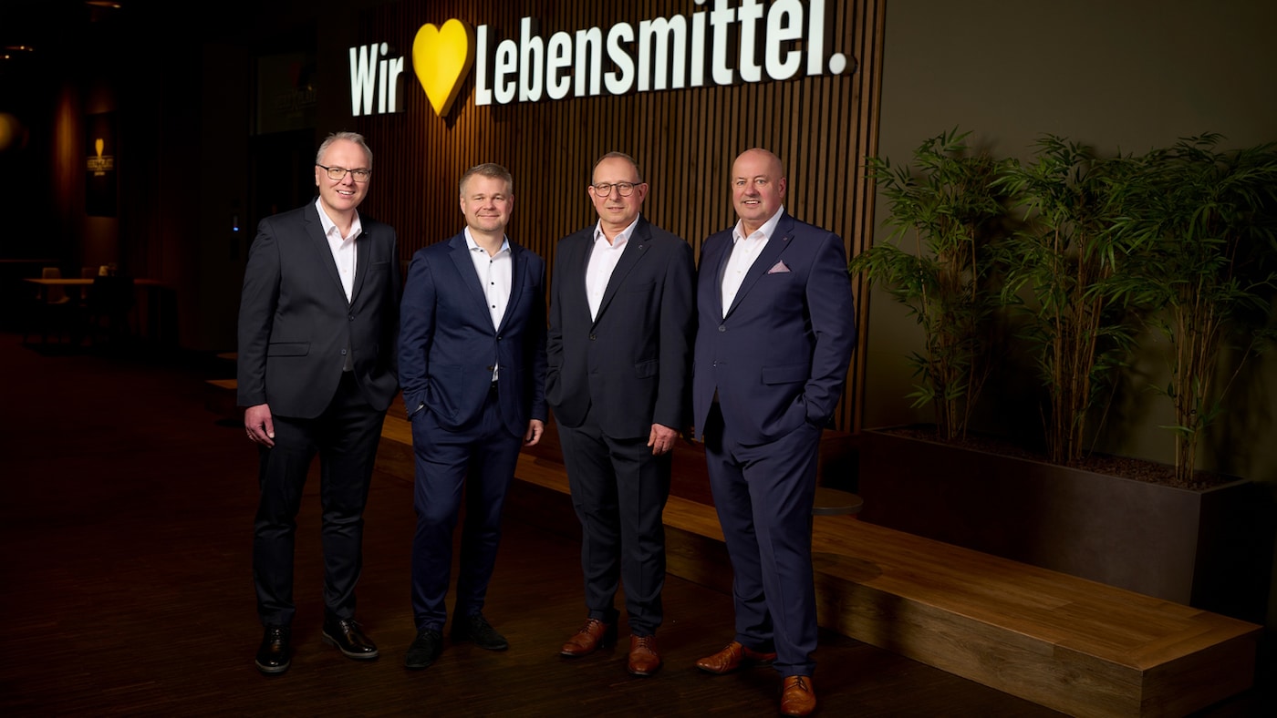 Gruppenfoto des vierköpfigen Vorstands von EDEKA Südwest vor einer Wand mit dem Marken-Claim 
