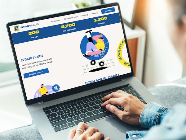 Person bedient auf einem aufgeklappten Laptop die Online-Plattform des EDEKA-Regional-Hubs. 