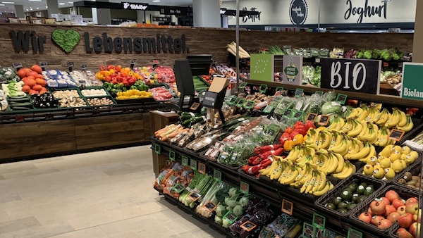 Zahlreiches Obst und Gemüse liegt in schrägen Gondeln in der Obst & Gemüseabteilung zum Kauf bereit.