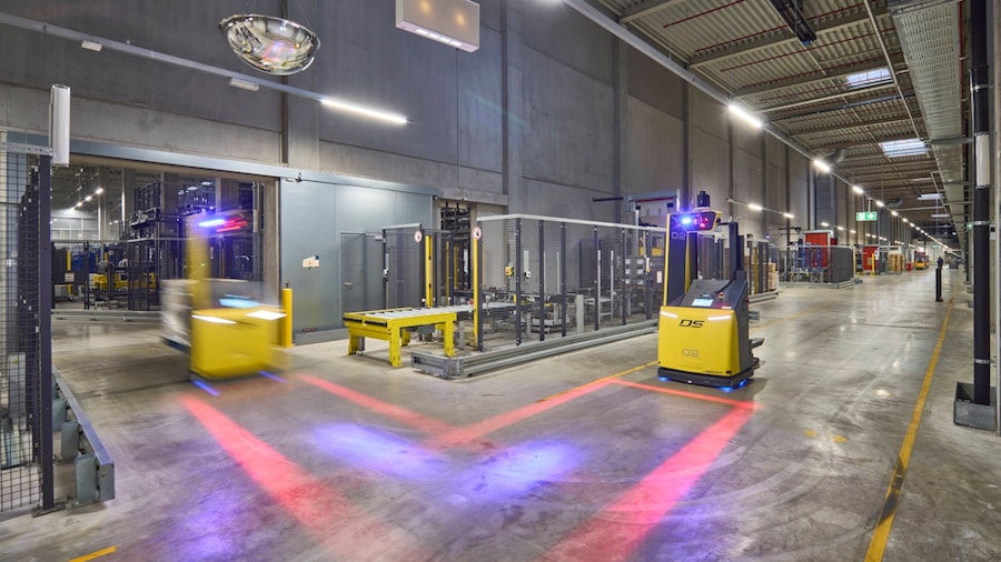 Im Lager fahren zwei autonome Flurförderfahrzeuge mit moderner Sensortechnik.